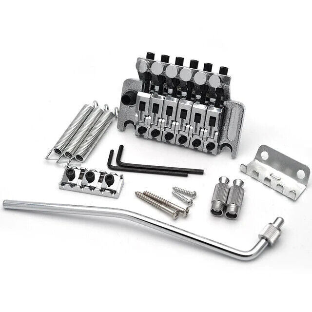 A set of guitar bridge parts including a double shake tremolo system, springs, screws, and tools, all laid out on a white background.