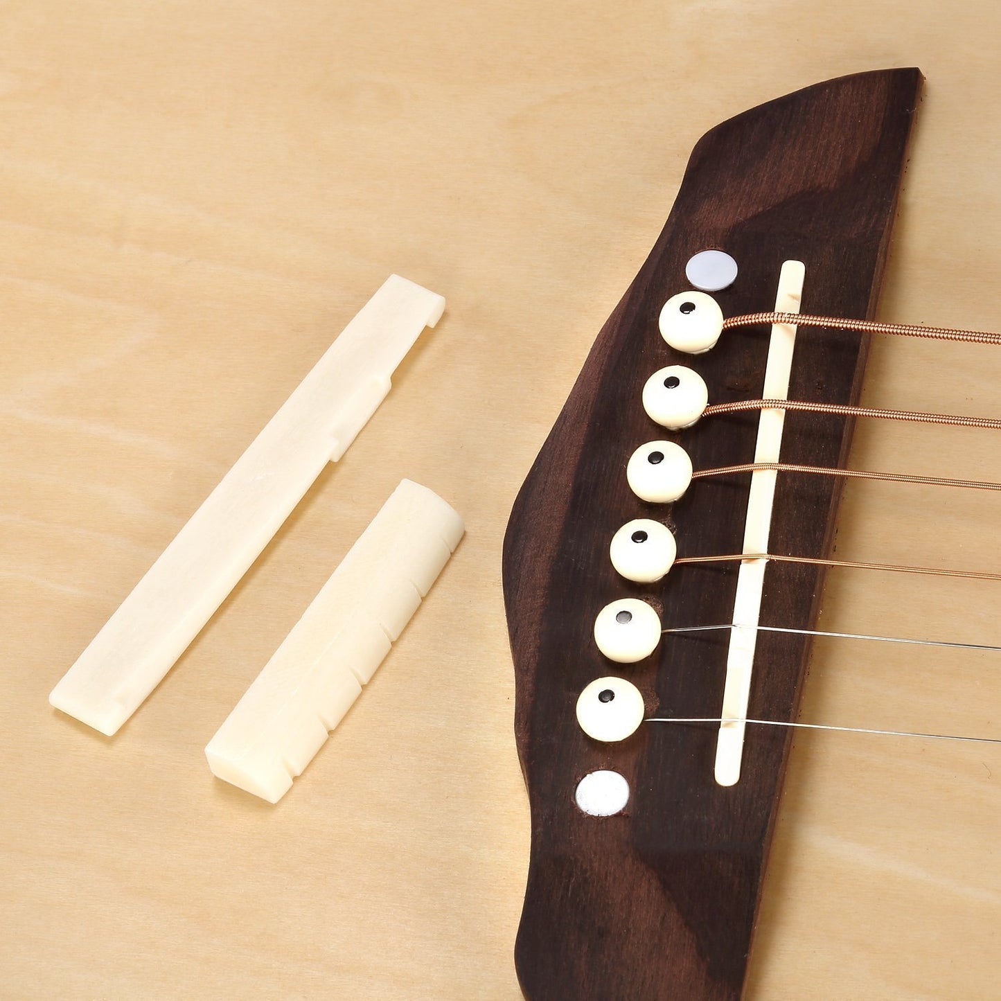 Guitar neck with white tuning pegs and a piece of wood on a beige background