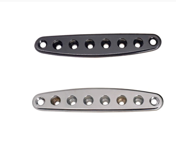 Two metal guitar bridge plates, one black and one silver, on a white background.