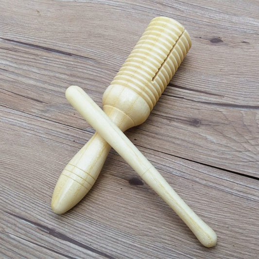 A wooden children's Orff percussion toy resembling a small marimba or xylophone, with a wooden mallet, placed on a wooden surface.