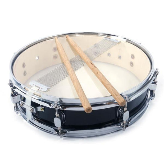 A black snare drum with drumsticks placed on top, against a white background.