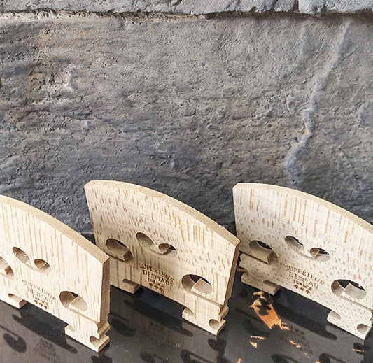 Three wooden bracket-like objects against a stone wall background