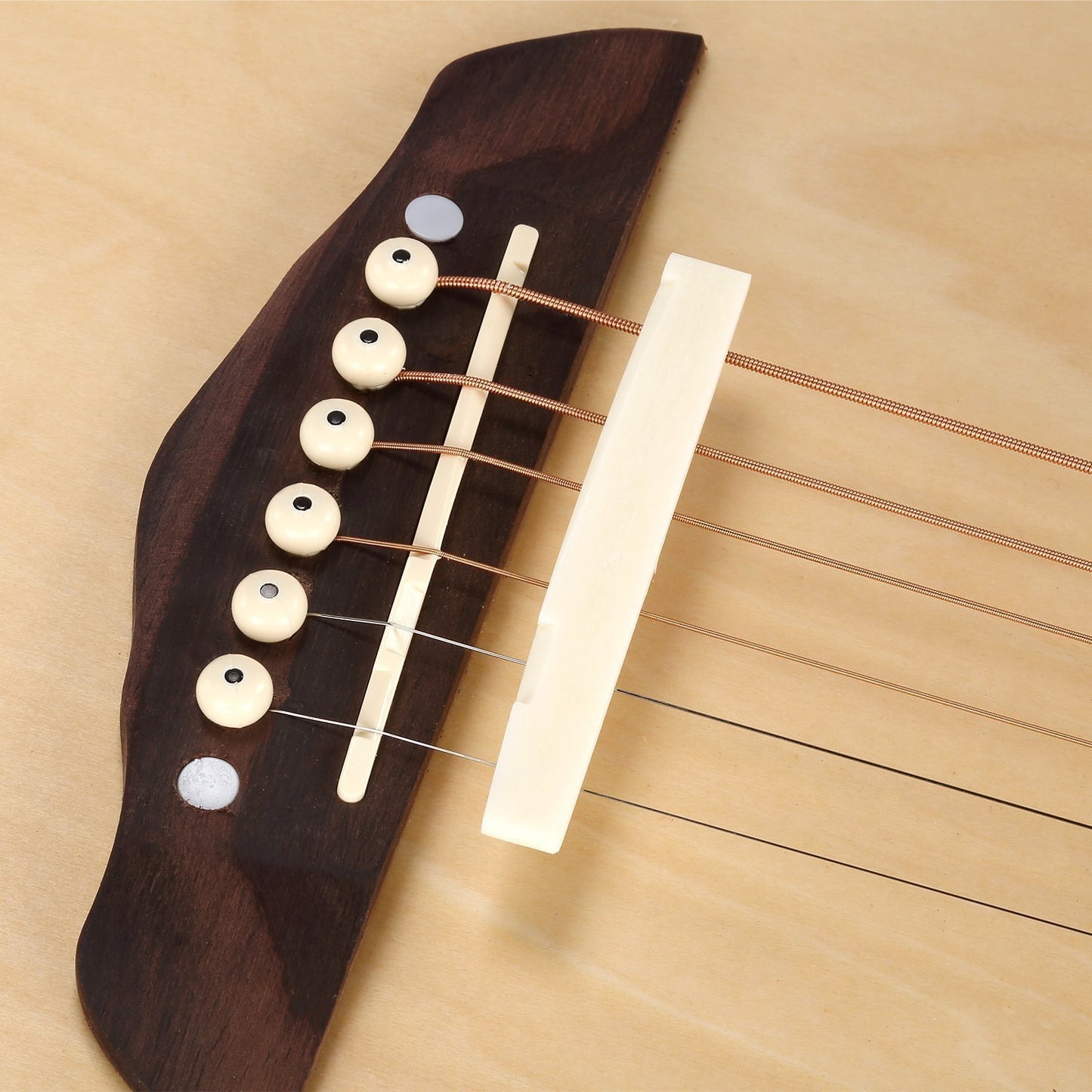 Close-up of a guitar's headstock with tuning pegs on a wooden background
