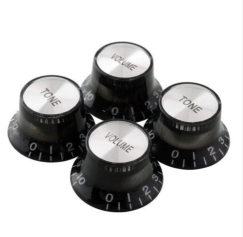 A set of five electric guitar knobs in black and white, with 'VOLUME' and 'TONE' labels on each knob.