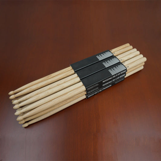 A bundle of Yamaha drumsticks laid on a wooden surface.