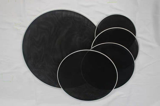 A set of black double-layer mesh drum heads of various sizes laid out on a white surface.