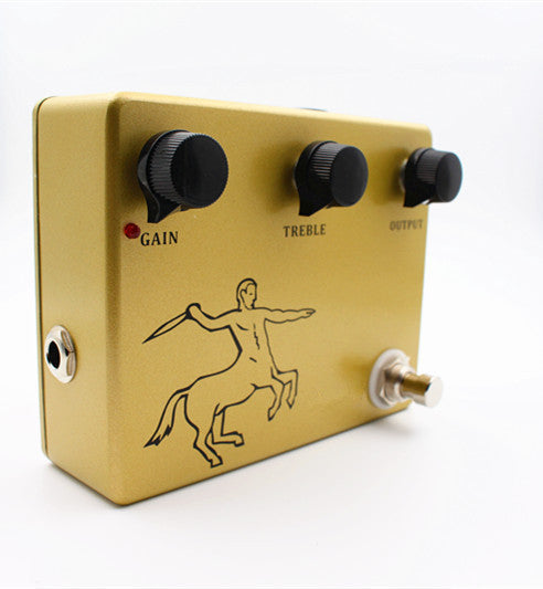 A gold-colored guitar pedal with knobs for gain, treble, and output, and a footswitch. The pedal has a black print of a centaur riding a horse.