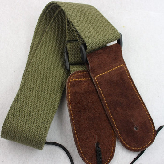 A cowhide head cotton guitar universal strap in green color with brown leather ends and black stitching.