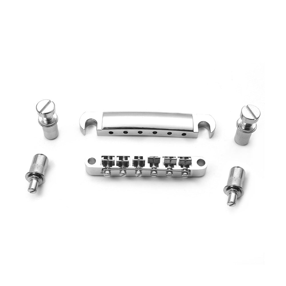 Set of metal guitar bridge components on a white background